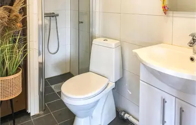 a bathroom with a toilet and a sink at Cozy Home In Brøttum With Kitchen