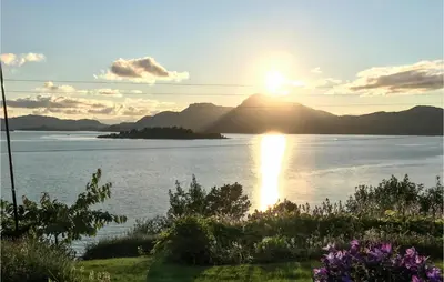 a view of the sun setting over a body of water at 1 Bedroom Amazing Apartment In Øydegard in Aspa