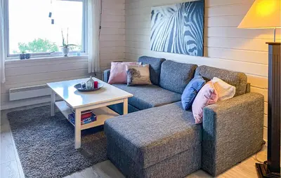 a living room with a couch and a table at 1 Bedroom Amazing Apartment In Øydegard in Aspa
