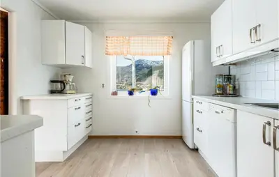 a kitchen with white cabinets and a window at 5 Bedroom Amazing Home In Strandebarm in Strandebarm