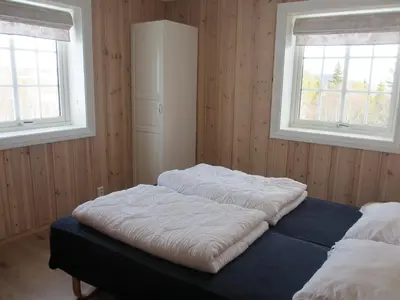 two beds in a room with two windows at Skåbu Camping in Skåbu