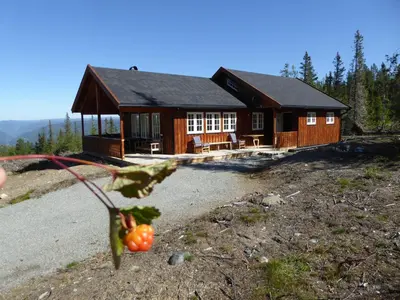 a log cabin with a table and chairs in front of it at Ny hytte i flott turterreng in Nore