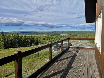 a deck with a view of a field and trees at Koselig leilighet med ski in ski out på Golsfjellet in Gol