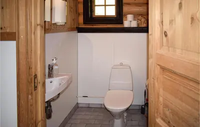 a bathroom with a toilet and a sink at Låven in Rauland