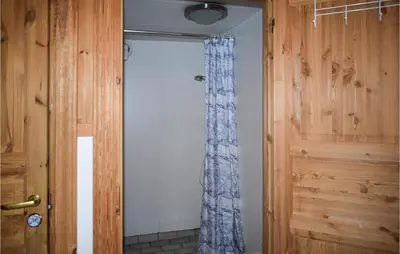 a bathroom with a shower with a blue curtain at Låven in Rauland