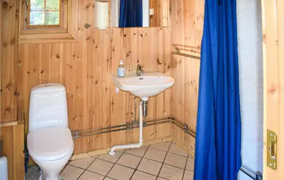 a wooden bathroom with a toilet and a sink at Stallen 1 in Rauland