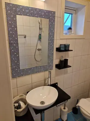 a small bathroom with a sink and a shower at Stranda apartment in Stranda