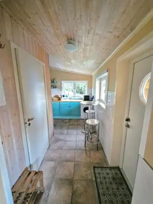 a small kitchen with blue cabinets and a table at Stranda apartment in Stranda