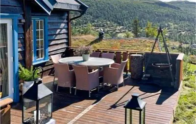 a deck with a table and chairs on a house at Nice Home In Rjukan With Wifi in Rjukan