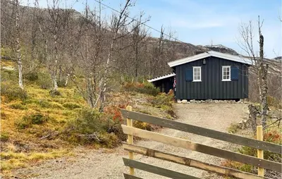 a small house on a hill next to a fence at Beautiful Home In Uvdal With Kitchen in Uvdal
