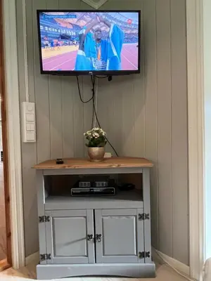 a flat screen tv on a wall with a table at Nørdre-Repp in Boverdalen