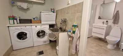 a bathroom with a washing machine and a sink at Relaxing place on Godøya in Godøy