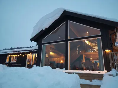 a house covered in snow at night at Flott hytte sentralt i Hallingdal in Ål
