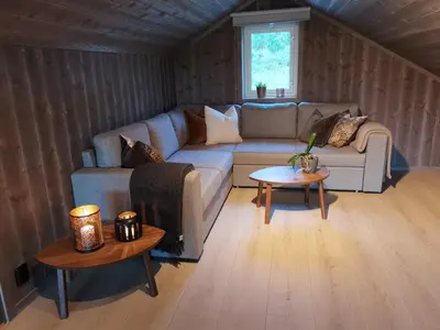 a living room with a couch and a table at Flott hytte sentralt i Hallingdal in Ål