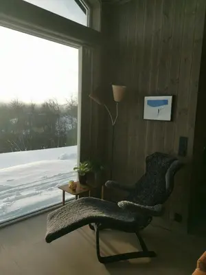 a living room with a chair and a window at Flott hytte sentralt i Hallingdal in Ål