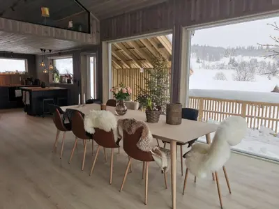 a dining room with a table and chairs with birds on them at Flott hytte sentralt i Hallingdal in Ål