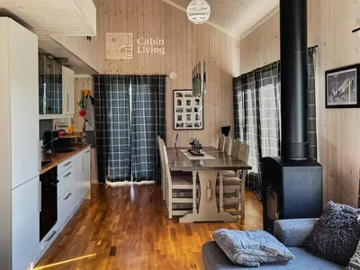 a kitchen with a table and a stove at Family friendly cabin Hemsedal GolfAlpin golf, ski-out, fireplace & wifi in Hemsedal