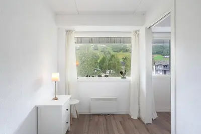 a white room with a window and a table with a lamp at Bjorli Apartment 203 (200m til Skitrekk) in Bjorli