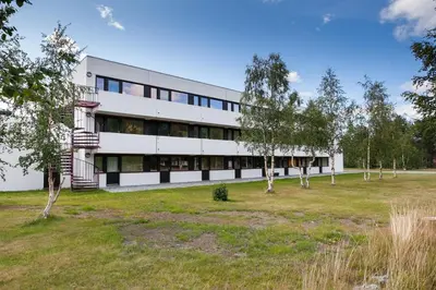a white building with trees in front of it at Bjorli Apartment 203 (200m til Skitrekk) in Bjorli