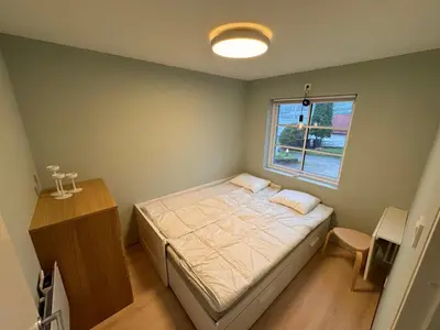 a small bedroom with a bed and a window at Fjord studio in Sunde