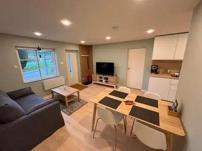 a kitchen and living room with a table and a couch at Fjord studio in Sunde