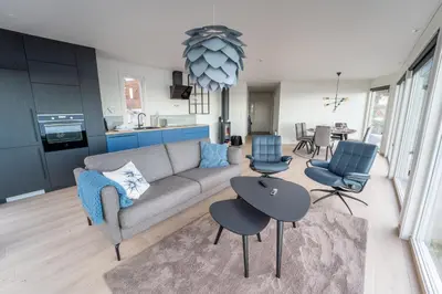 a living room with a couch and a table and chairs at Runde Panorama - Trollvogga in Runde