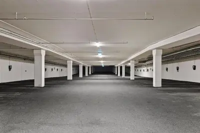 an empty parking lot with white columns in an empty parking garage at Fyri Tunet Hemsedal in Hemsedal