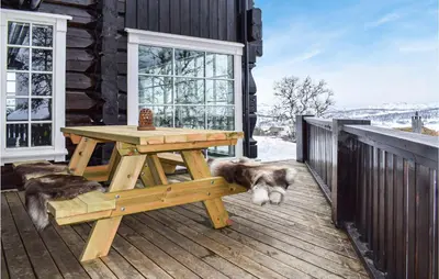 two dogs laying around a picnic table on a deck at Beautiful Home In Rauland With Sauna in Rauland