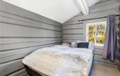 a bedroom with a bed in a room with a window at Beautiful Home In Rauland With Sauna in Rauland