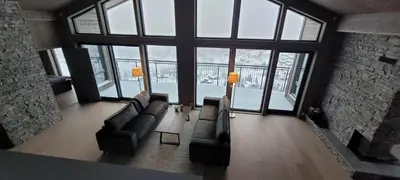 a living room with a couch and a large window at Gausta Residence in Gaustablikk