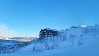a building on the side of a snow covered mountain at Gausta Residence in Gaustablikk