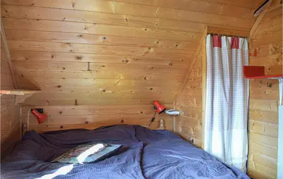 a bedroom with a bed in a wooden cabin at Gorgeous Home In Aksdal With Kitchen in Aksdal