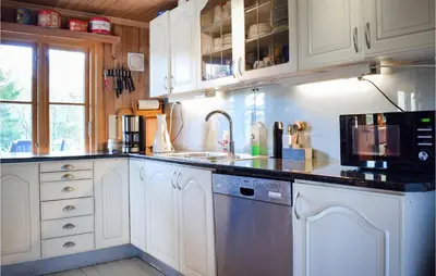 a kitchen with white cabinets and a sink and a microwave at Gorgeous Home In Aksdal With Kitchen in Aksdal