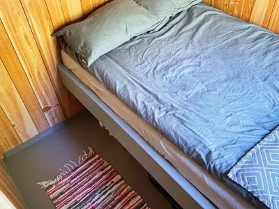 a bed sitting on top of a table with a rug at 4 person holiday home in Svelgen-By Traum in Sørgulen