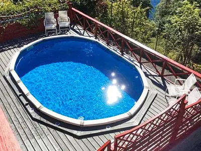a large blue swimming pool on a wooden deck at 8 person holiday home in Bruvik-By Traum in Bruvik