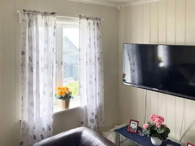 a living room with a television and a window at 6 person holiday home in Hernar-By Traum in Bøvågen