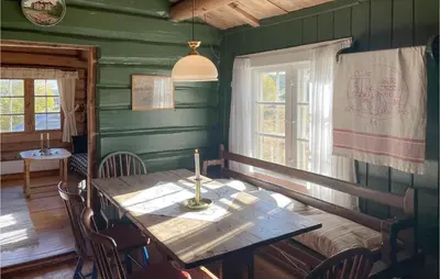 a dining room with a wooden table and a window at 3 Bedroom Nice Home In Kvam in Kvam