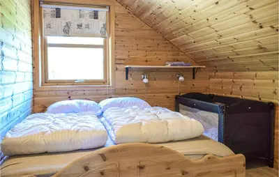 a bedroom with two beds in a wooden cabin at Nice Home In Os With House Sea View in Oma