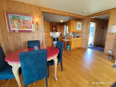 a dining room and kitchen with a red table and blue chairs at Nordgards Hagen in Lillehammer
