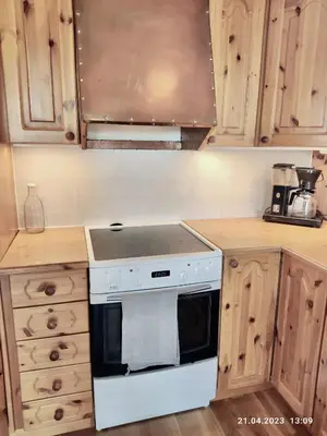 a kitchen with a white stove and wooden cabinets at Nordgards Hagen in Lillehammer