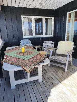 a table and two chairs on a deck with a table at Nordgards Hagen in Lillehammer