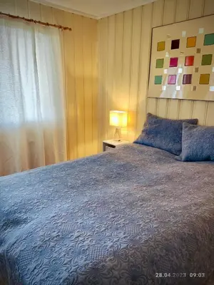 a bedroom with a large bed with a blue blanket at Nordgards Hagen in Lillehammer