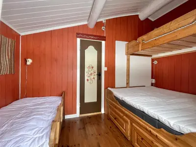 two bunk beds in a room with red walls at Vasethytta - cabin with a lovely view in Ron