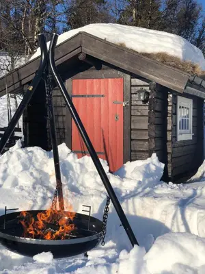 a fire pit in the snow in front of a cabin at Vasethytta - cabin with a lovely view in Ron
