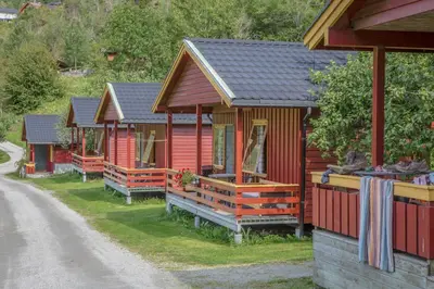 a row of red cabins on the side of a road at Pluscamp Sandvik in Gaupne