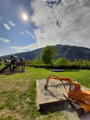 a bulldozer sitting in a field next to a playground at Pluscamp Sandvik in Gaupne