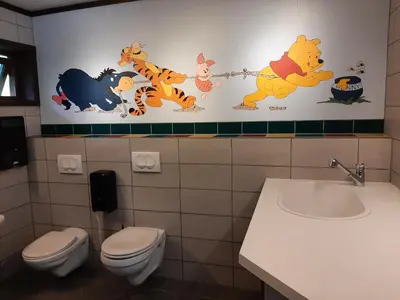 a bathroom with winnie the pooh characters on the wall at Pluscamp Sandvik in Gaupne
