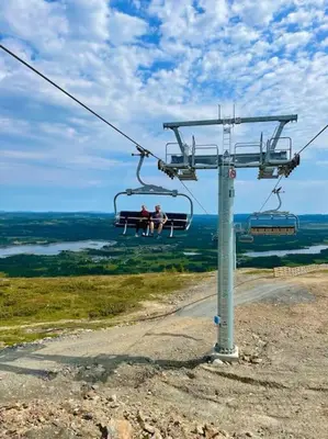 two people are sitting on a ski lift at Flott fritidsleilighet i Bualie på Golsfjellet in Gol