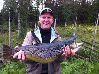 a man holding a brown trout in his hands at Flott fritidsleilighet i Bualie på Golsfjellet in Gol