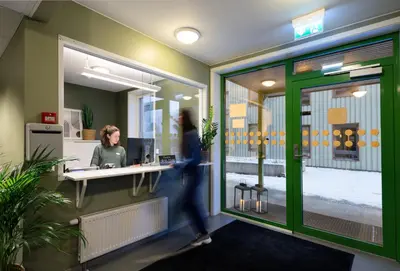 a woman walking through an office at Rumi Hostel in Trondheim